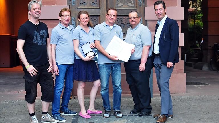 Mit Urkunde und Ehrenmedaille vor dem Stadtwappen am Grafeneckart: Oberbürgermeister Christian Schuchardt (rechts) hat die Gründer und Macher des WürzburgWiki (von links: Ralf Thees, Günter Keller, Julia Breunig, Wolfgang Keller und Roland Dörfler) für ihr ehrenamtliches Engagement ausgezeichnet.