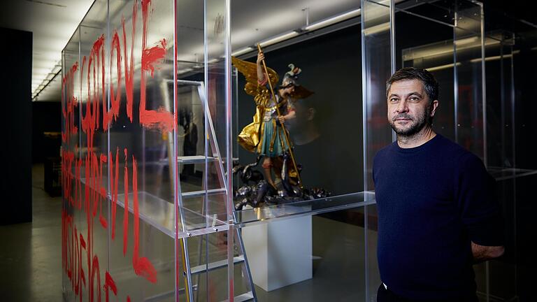 &nbsp;Michael Müller vor einer Arbeit, die eine barocke Skulptur des Heiligen Michael mit einem Zitat der frühverstorbenen Künstlerin Ana Mendieta kombiniert: 'Da ist ein Teufel in mir.' St. Michael und der Drache werden so zum Symbol für das Böse, das in uns allen steckt.