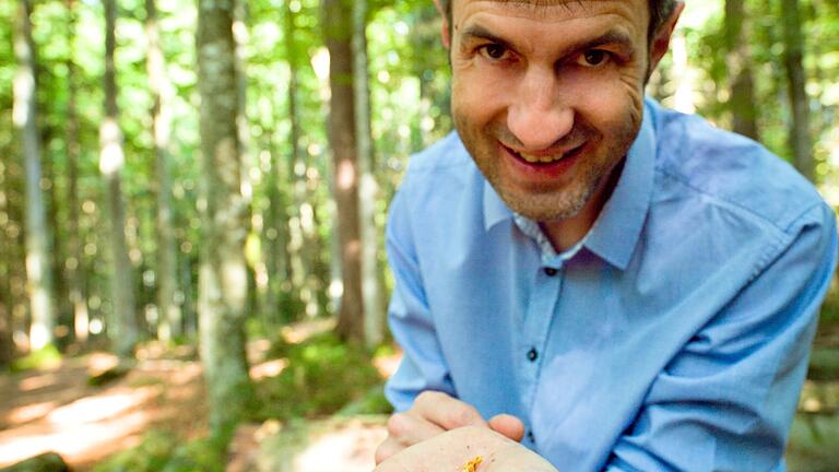 Professor Jörg Müller mit einem lebenden Borkenkäfer auf der Hand (der kleine schwarze Punkt).