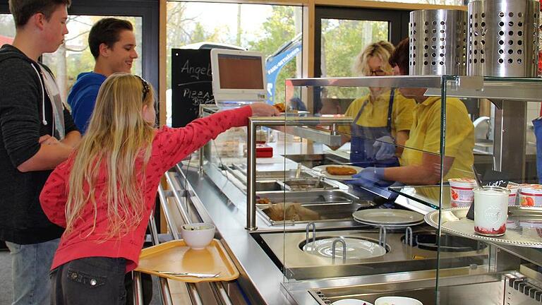 Cafeteria im Schulzentrum Lauda feiert 20-jähriges Bestehen       -  (bix)   Die Entwicklung über die zwei Jahrzehnte verlief teilweise durchaus atemberaubend: Ausgestattet mit einer Baby-Badewanne, Salatschüsseln und Schneidebrettchen wagten einige Mütter zum Schuljahr 1994/95 den Anfang in der Aula des Martin-Schleyer-Gymnasiums Lauda, um dort mit viel Engagement den Schülern in der Mittagspause eine Kleinigkeit anzubieten. Nicht entmutigt durch fehlenden Herd, nicht vorhandenes Wasser und noch ohne Strom erwuchs dennoch aus dieser bescheidenen Premiere der längst etablierte Verein &bdquo;Cafeteria im Schulzentrum &ndash; Eltern kochen für Schüler&ldquo;, der nun kurz vor den Sommerferien offiziell seinen 20. Geburtstag feiert. Seit November 2013 in erheblich vergrößerten Räumlichkeiten, wobei der neue Speisesaal mit rund 150 Sitzplätzen die doppelte Anzahl als zuvor aufweist, präsentierte man damals den eben erst fertiggestellten insgesamt knapp 550 000 Euro teuren An- und Umbau der breiten Öffentlichkeit. Seit September 2012 gehe das Team unter der Leitung des Küchenchefs Christian Leue-Huband im vergrößerten Bereich mit noch einmal erhöhter Motivation seiner Tätigkeit nach, äußerten die Vorsitzende und die Schriftführerin. Besonders stolz seien sie allerdings auf das Cafeteriateam, das derzeit neben den drei Hauptamtlichen aus einem etwa 70-köpfigen Personalstamm bestehe, darunter zwei Männer, so die beiden Vorstandsmitglieder abschließend. &bdquo;Die Arbeitsstunden der Ehrenamtlichen summieren sich dabei auf rund 6000 im Jahr.&ldquo;