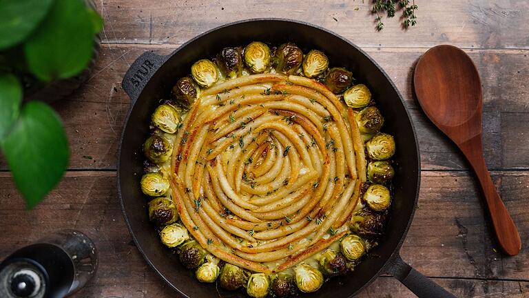 Eine Schupfnudelpfanne auf einem Holztisch       -  Festlich, aber unkompliziert: Diese Schupfnudelpfanne vereint klassische Aromen mit moderner Leichtigkeit – ein perfektes Weihnachtsgericht.