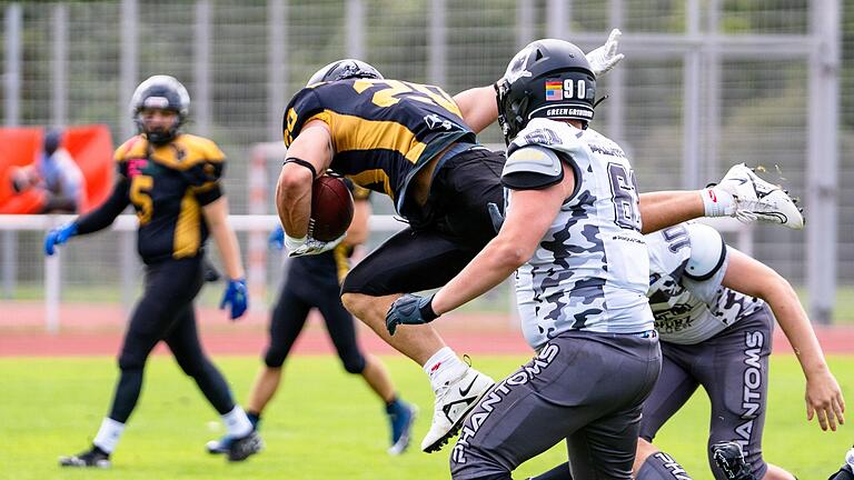 Running Back Mervin Götzelmann (mit Ball) von den Würzburg Panthers im Spiel gegen die Bamberg Phantoms im Duell mit seinen Gegenspielern