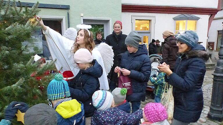 Der Weihnachtsengel dekorierte den Christbaum mit selbstgebastelten Schmuck der Kinder. Im Hintergrund Dettelbachs Bürgermeisterin Christine Konrad.