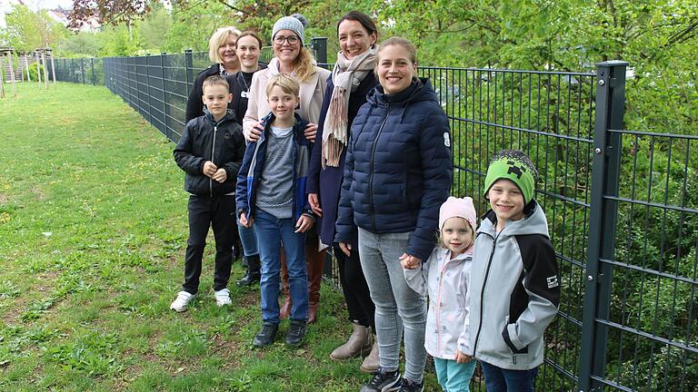 Schulleiterin, Eltern und Kinder freuen sich über den neuen Zaun an der Siedlungsgrundschule