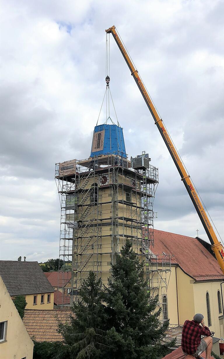 Ein Kran hob den ersten Teil des neuen Turmhelms wieder auf den Kirchturm in Stadelschwarzach. Bei einem Sturm wurde sie quasi davon geblasen.