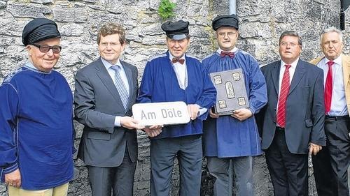 „Am Döle“ mit eigener Anschrift - (mr) Die Ehrengäste bei der Aufstellung des Straßenschildes „Am Döle“ standen dicht gedrängt auf dem Pflaster, das bisher zur Segenturmgasse gehörte. Der kurze Weg, der auf einen der malerischsten Flecken Heidingsfelds zuläuft, das Vereinsdomizil der Hetzfelder Flößerzunft, trägt nun auch den Namen dieses Wahrzeichens. Oberbürgermeister Georg Rosenthal gestand, dass der Stadtrat auf diese Straßenbenennung erst durch die örtlichen Vereine aufmerksam gemacht werden musste. Als Teil der mittelalterlichen Stadtmauer diente das Döle genannte Brückenhäuschen ursprünglich der Überwachung des Bachbetts. Ende des 18. Jahrhunderts wurde das Döle zur Wohnung der Heidingsfelder Stadthebamme umgebaut. 1922 gelangte es in den Besitz von Rudolf Schiestl, der als Professor für Grafik an der Kunstgewerbeschule in Nürnberg tätig war. Rudolf Schiestl und seine Brüder, der Bildhauer Heinz und der Maler Matthäus, gehörten der 1905 gegründeten Flößerzunft an. Im Bild (von links): Altoberbürgermeister Klaus Zeitler, OB Georg Rosenthal, Lothar Hartlieb, Floßmeister der Hetzfelder Flößerzunft, Christoph Bergrad mit der Chronik der Zunft, Bürgermeister Adolf Bauer und Altoberbürgermeister Jürgen Weber. „Am Döle“ mit eigener Anschrift - (mr) Die Ehrengäste bei der Aufstellung des Straßenschildes „Am Döle“ standen dicht gedrängt auf dem Pflaster, das bisher zur Segenturmgasse gehörte. Der kurze Weg, der auf einen der malerischsten Flecken Heidingsfelds zuläuft, das Vereinsdomizil der Hetzfelder Flößerzunft, trägt nun auch den Namen dieses Wahrzeichens. Oberbürgermeister Georg Rosenthal gestand, dass der Stadtrat auf diese Straßenbenennung erst durch die örtlichen Vereine aufmerksam gemacht werden musste. Als Teil der mittelalterlichen Stadtmauer diente das Döle genannte Brückenhäuschen ursprünglich der Überwachung des Bachbetts. Ende des 18. Jahrhunderts wurde das Döle zur Wohnung der Heidingsfelder Stadthebamme umgebaut. 1922 gelangte es in den Besitz von Rudolf Schiestl, der als Professor für Grafik an der Kunstgewerbeschule in Nürnberg tätig war. Rudolf Schiestl und seine Brüder, der Bildhauer Heinz und der Maler Matthäus, gehörten der 1905 gegründeten Flößerzunft an. Im Bild (von links): Altoberbürgermeister Klaus Zeitler, OB Georg Rosenthal, Lothar Hartlieb, Floßmeister der Hetzfelder Flößerzunft, Christoph Bergrad mit der Chronik der Zunft, Bürgermeister Adolf Bauer und Altoberbürgermeister Jürgen Weber.