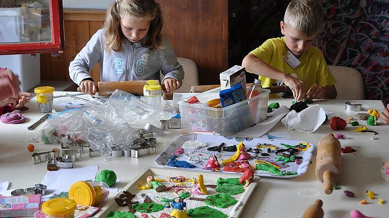 Die Back-Gruppe arbeitet an einer dreistöckigen Torte für das Abschlussfest. Am ersten Projekttag bastelten die Kinder Disneyfiguren aus Fondant, die später die Torte verzieren sollen. Ein beliebtes Motiv: natürlich Schneewittchen.