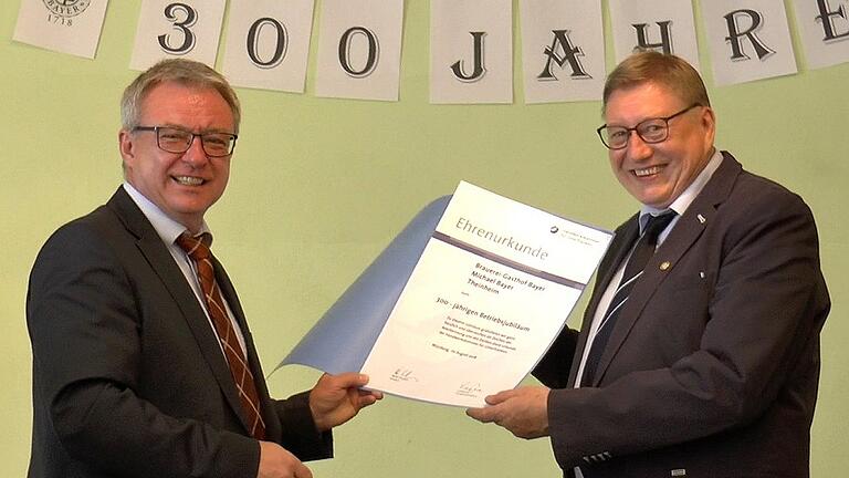 Frank Weht von der Handwerkskammer (links) überreichte Gastwirt Michael Bayer anlässlich des 300-jährigen Bestehens  der Brauerei Bayer in Theinheim eine Ehrenurkunde.