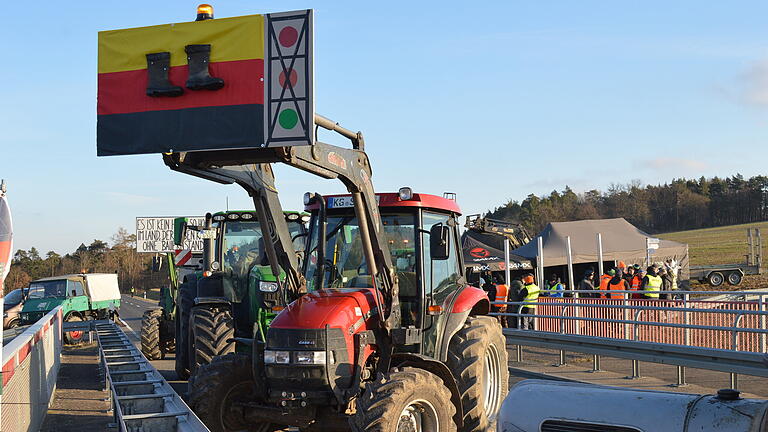 Bei der bundesdeutschen Protestaktion der Landwirte am 8. Januar 2024 war auch an der Auffahrt zur A 71 bei Münnerstadt einiges geboten. Auf der Fahrbahn hoch zur Autobahn hielt sich die Anzahl der Traktoren zwar in Grenzen. Auf der Brücke über diese Auffahrt, unweit der Schlegelwarte Münnerstadt, trafen sich ab sechs Uhr morgens rund 30 Landwirte aus den Landkreisen Bad Kissingen, Rhön-Grabfeld und Schweinfurt mit ihren Fahrzeugen, um auch über dem Autobahn-Zubringer ihren Protest zu zeigen. Unterdes machte auch der Pendler-Parkplatz bei Burglauer seinem Namen alle Ehre: Die Landwirte pendelten nämlich immer wieder mit ihren Traktoren zwischen Burglauer und Bad Neustadt hin und her - natürlich im Schneckentempo, um auf sich und ihre Anliegen aufmerksam zu machen.