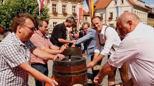 2. Bürgermeister Hans-Georg Häfner, 1. Bürgermeister Michael Ziegler und Stadtpfarrer Thomas Klemm (von rechts) beim Anzapfen, assistiert von den Vertretern der Brauereien Weiss Rössl, Roppelt-Bräu und &bdquo;Eschenbacher Privatbrauerei&ldquo; (von links).