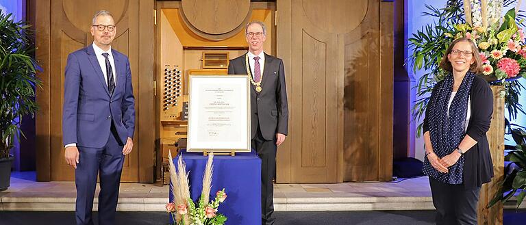Peter Bofinger (links) wurde auf dem Stiftungsfest 2021 die Julius-Maximillians-Verdienstmedaille verliehen. In der Mitte: Unipräsident Paul Pauli, rechts die Vizepräsidentin und Laudatorin Doris Fischer.