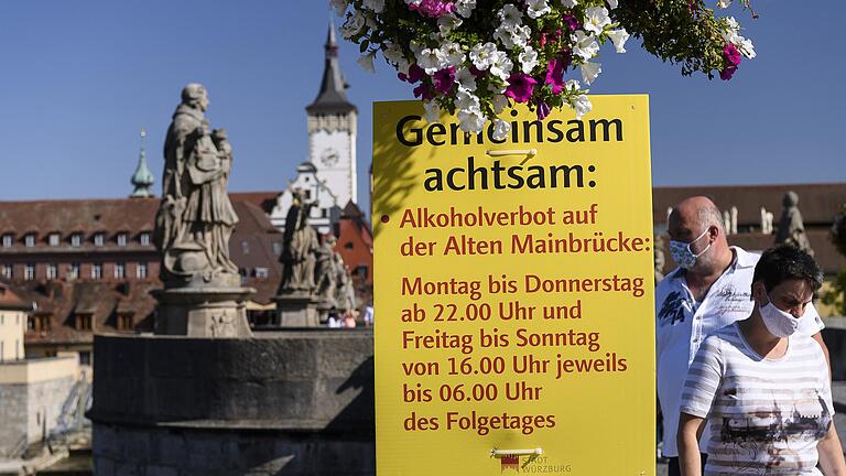 Große Schilder auf der Alten Mainbrücke in Würzburg wiesen auf die verschärften Würzburger Corona-Regeln hin.&nbsp;