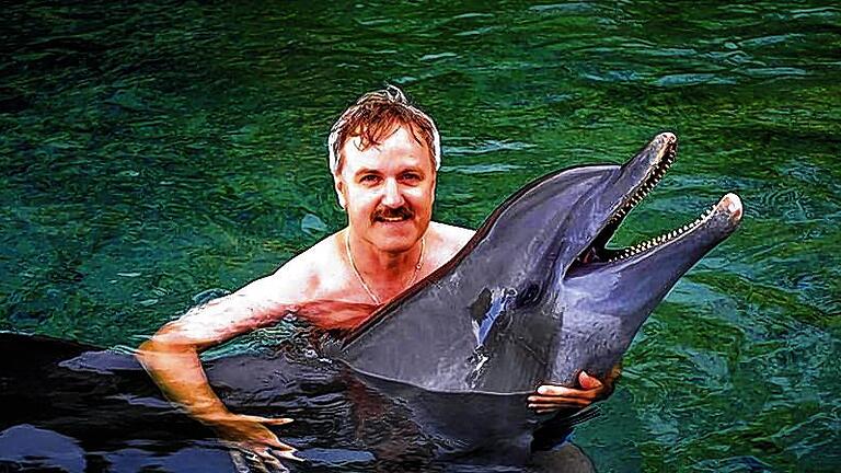 Meet and greet: Thomas Breitenbach beim Schwimmen mit einem Delfin.