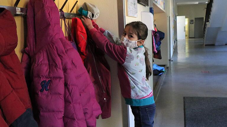 Laura hängt am ersten Schultag nach der Corona-Pause ihre Jacke auf. Nur einzeln und mit Maskie dürfen die Kinder in die Garderobe. Laura hängt am ersten Schultag nach der Corona-Pause ihre Jacke auf. Nur einzeln und mit Maskie dürfen die Kinder in die Garderobe.
