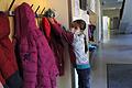 Laura hängt am ersten Schultag nach der Corona-Pause ihre Jacke auf. Nur einzeln und mit Maskie dürfen die Kinder in die Garderobe.