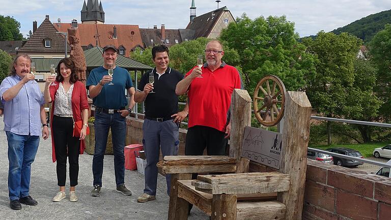 Wie soll der Stuhl auf der Alten Saalebrücke in Gemünden heißen, auf den hier (von links) Jürgen Sommerer, Jasna Blaic, Roland Ziegler, Miro Blaic und Peter Reichel anstoßen?