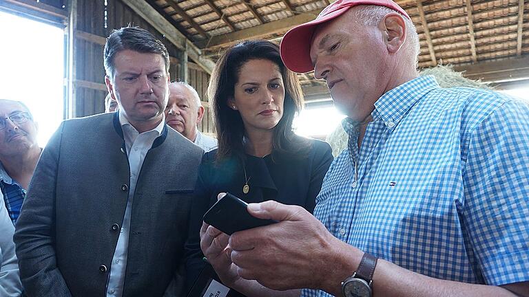 Landrat Thomas Habermann (rechts) zeigte Staatsministerin Michaela Kaniber Fotos von einem Wolfsriss. Mit im Bild Sandro Kirchner, auf dessen Einladung die Ministerin in die Rhön kam.