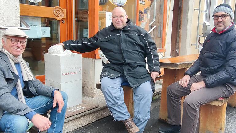 Vor der Tür der geschlossenen Bäckerei sitzen Bildhauer Thomas Reuter, Bäckermeister Andreas Rother und Bürgermeister Christian Luksch (von links)&nbsp; und suchen nach Lösungen für eine Genossenschaft.