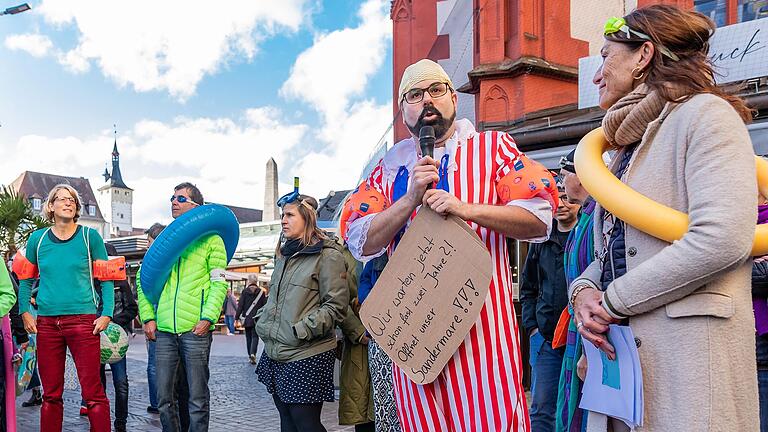 Rund 20 Menschen versammelten sich am Samstag zu einem Flashmop auf dem Marktplatz. Ihre Forderung: 'Öffnet unser Sandermare!' Rund 20 Menschen versammelten sich am Samstag zu einem Flashmop auf dem Marktplatz. Ihre Forderung: 'Öffnet unser Sandermare!'