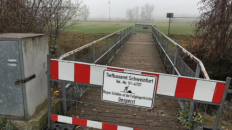 Die Brücke über die Wern, die die Sportplätze der DJK Schweinfurt verbindet, wurde kurzfristig von der Stadt gesperrt, weil sie marode ist. Die Sperrung schränkt das Sporttreiben vor Ort erheblich ein, nächstes Jahr soll eine neue Brücke gebaut werden.