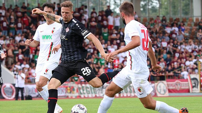 Kickers-Neuzugang Janik Bachmann (am Ball gegen die Augsburger Simon Asta und Dong-Wong Ji) drängt sich in der Vorbereitung mit guten Leistungen für die Rolle als Neumann-Nachfolger in der Abwehrkette förmlich auf. Kickers-Neuzugang Janik Bachmann (am Ball gegen die Augsburger Simon Asta und Dong-Wong Ji) drängt sich in der Vorbereitung mit guten Leistungen für die Rolle als Neumann-Nachfolger in der Abwehrkette förmlich auf.