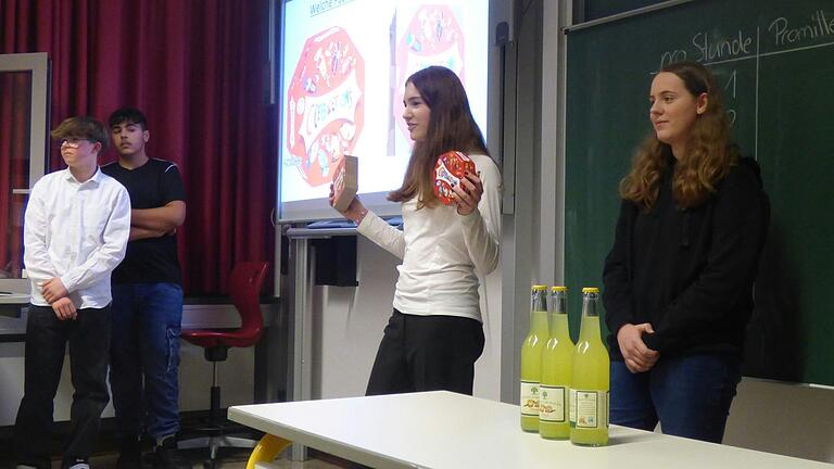 Im Bild zu sehen sind Schüler zum Thema „Mathematik im Alltag“ bei der Volumenberechnung einer Pralinen-Packung.