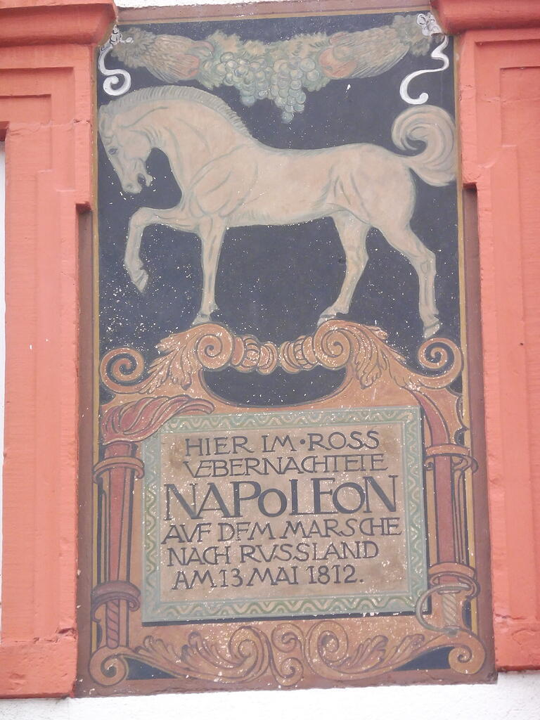 Fresko am ehemaligen Gasthaus „Weißes Ross“ in Lengfurt am dortigen Marktplatz. Demzufolge hätte Napoleon hier auf dem Weg zum Russland-Feldzug genächtigt, was allerdings nicht durch die historischen Quellen belegt ist.