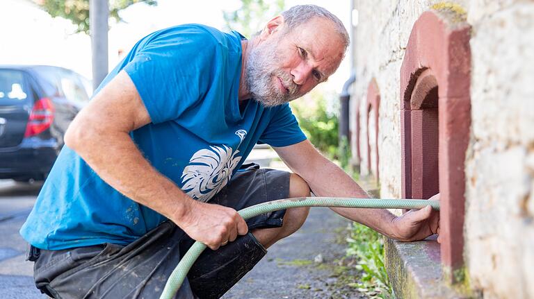 Norbert Dürr versucht das Wasser aus dem Keller eines Verwandten zu pumpen.