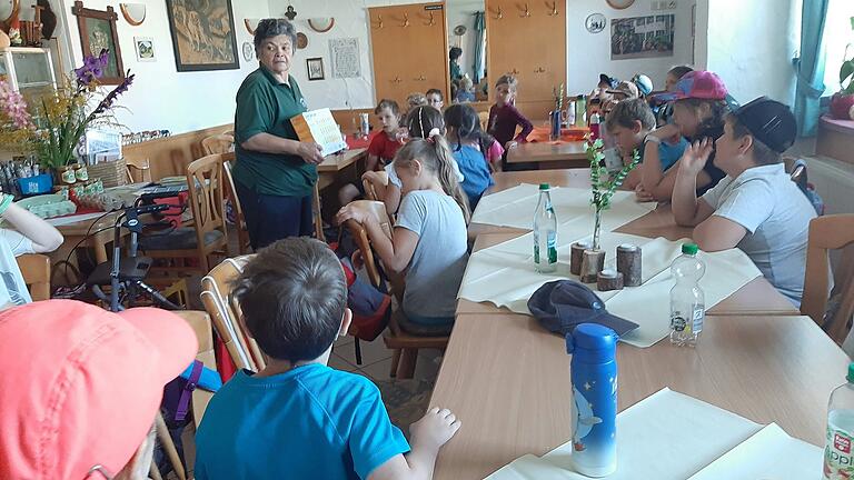 Irma Stierhof zeigt den Kindern anhand einer Schautafel den Entwicklungszyklus eines bebrüteten Hühnereis.