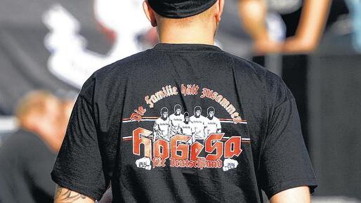 Gefährliche Fankultur: Ein Teilnehmer der Kölner Krawalle trägt ein T-Shirt, auf dem seine rechte Gesinnung und zugleich ein Bezug zum Fußballsport hergestellt werden: &bdquo;HoGeSa&ldquo; steht für Hooligans gegen Salafisten. Dass sich die Aktivisten Hooligans nennen, ein Begriff aus den 1980er und 1990er Jahren, ist laut dem Würzburger Fanforscher Professor Harald Lange eine bewusste Entscheidung: &bdquo;Das ist Programm&ldquo;.