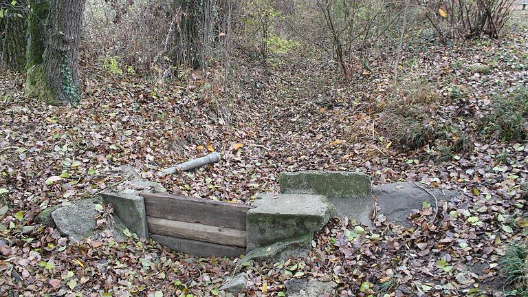 Der nördliche Arm des Unkenbachs in Bischwind ist trockengefallen. Das Wehr, von dem aus auch ein Abzweigrohr zum benachbarten alten Brunnenhäuschen führt, ist ohne Wasser.