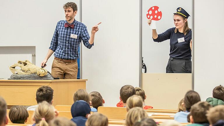 In der Kinderuni im Hörsaal Audimax in der Universität in Würzburg lauschen Kinder einer Vorlesung von Dozenten Sebastian Market und Veronika Perschin im Jahr 2022.