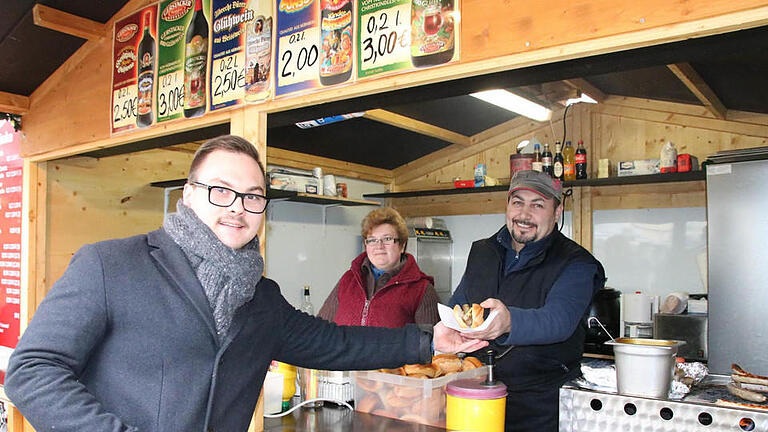 Raphael Zehe (von links) besuchte gestern trotz des Anschlags in Berlin den Bad Kissinger Weihnachtsmarkt und kaufte eine Wurst bei Elena und Spartak Badikjan. Foto: Ralf Ruppert       -  Raphael Zehe (von links) besuchte gestern trotz des Anschlags in Berlin den Bad Kissinger Weihnachtsmarkt und kaufte eine Wurst bei Elena und Spartak Badikjan. Foto: Ralf Ruppert