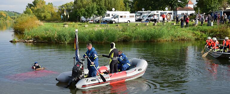 Gäste des nahen Wohnmobilstellplatzes (hinten) hatten den Unfall beobachtet und die Rettungskräfte alarmiert. Das rote Dach des komplett versunkenen Autos ist am linken Bildrand vor dem Taucher zu erkennen.