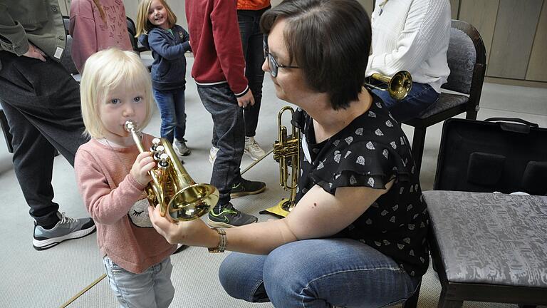 Die zweijährige Sarah Seuffert probiert schon mal mutig die Trompete. Rechts Lehrerin Yvonne Göb.