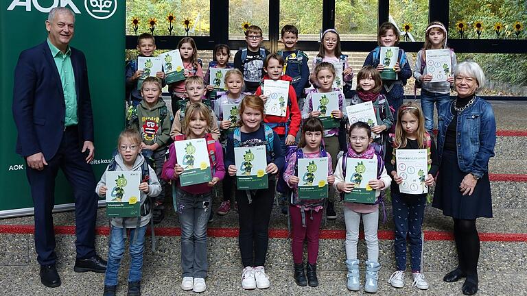 Die erste Klasse der Grundschule Üchtelhausen mit Schulleiterin Kerstin Weber und AOK Direktor Frank Dünisch bei der Übergabe der 'Schulranzen-Fit'-Aktion