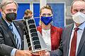 Vier Satelliten dieser Bauart wurden am Montag ins All befördert: Bayerns Wirtschaftsminister Hubert Aiwanger (rechts) und Digitalministerin Judith Gerlach mit Professor Klaus Schilling (links).