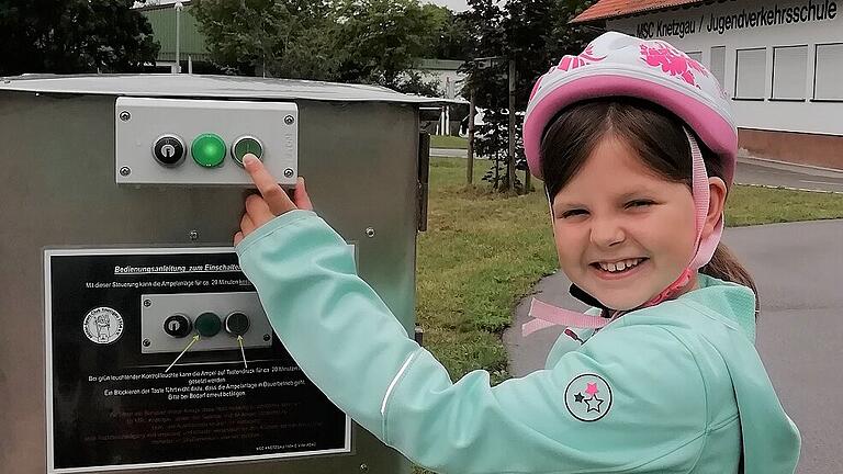 Die kleine Frieda Finger freut sich, dass sie die Ampelanlage am Verkehrsübungsplatz der Jugendverkehrsschule in Knetzgau selbst per Knopfdruck einschalten kann.
