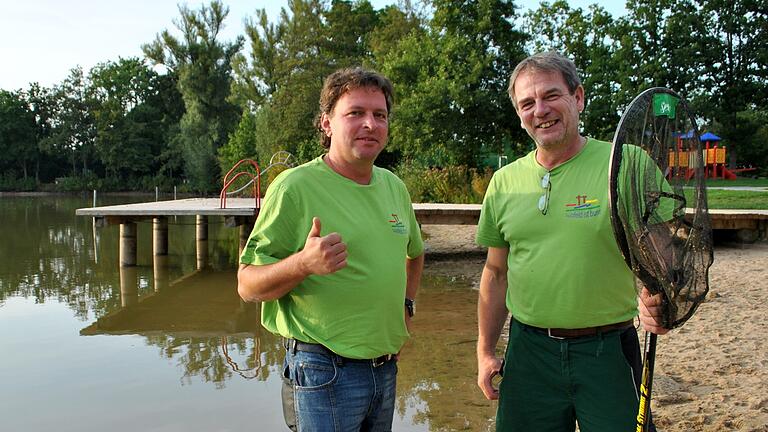 Bürgermeister Jürgen Heusinger freut sich,  Gemeindearbeiter Harald Endres kann keine Algen mehr herausfischen: Der Sulzfelder Badesee ist wieder freigegeben.