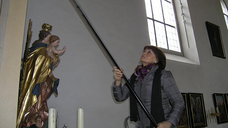 Elisabeth Groß macht mit einem langen Staubwedel Spinnenweben an einem Seitenaltar in der Hoheimer Kirche St. Georg weg. Elisabeth Groß macht mit einem langen Staubwedel Spinnenweben an einem Seitenaltar in der Hoheimer Kirche St. Georg weg.