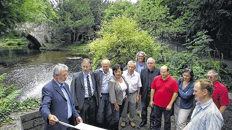 Verwunschenes Kleinod: Gartenamtsleiter Dieter Müller (links) erklärt den Mitgliedern des Planungs- und Umweltausschusses die Maßnahmen, um die Anlage am Burkarder See wieder attraktiv zu machen.Foto: Theresa Müller