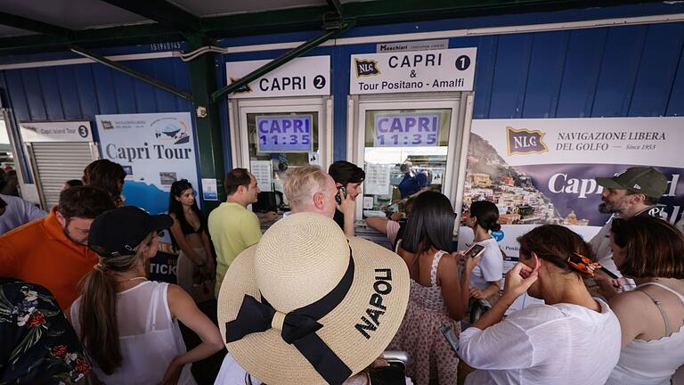 Capri ohne Wasserversorgung: Touristen-Stopp       -  Reisende drängen sich vor Ticket-Schaltern am Molo Beverello für die Fähren, die unter anderem nach Capri fahren. Touristen dürfen nun wieder auf die Insel.