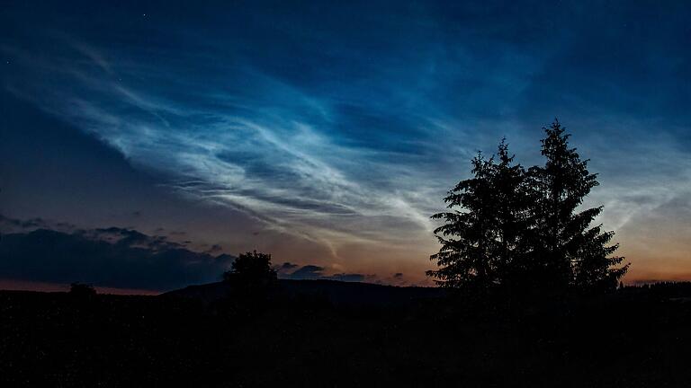 Dieses Bild zeigt leuchtende Nachtwolken vor zwei Jahren während der Mitternachtsdämmerung in der Rhön. Sie haben die typisch schleierartige Form.