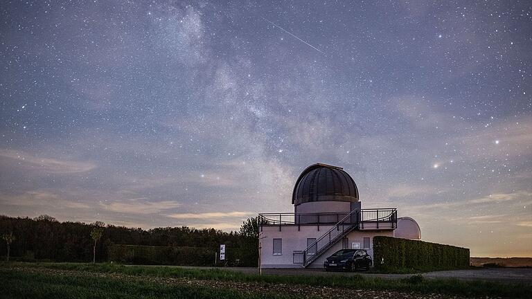 Die Sternwarte Weikersheim bei Nacht und der gestirnte Himmel.