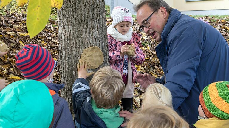 Mit Spaß und Spiel sollen die Erst- und Zweitklässler in Rieneck in und nach der Schule in der offenen Ganztagesbetreuung glücklich sein. Hier leitet Rektor Michael Bäuerlein die Kinder an, mit Ton und Lehm Gesichter an die Bäume zu modellieren.