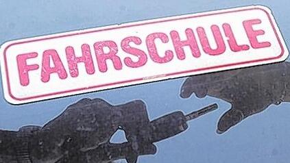 Schlüsselübergabe: Ein Fahrlehrer überreicht seiner Fahrschülerin den Schlüssel zum Fahrzeug. Doch unterwegs auf den Straßen wirkt schon allein das Schild &bdquo;Fahrschule&ldquo; auf viele anderen Verkehrsteilnehmer wie ein Reiz und verleitet sie zum Überholen oder Drängeln.