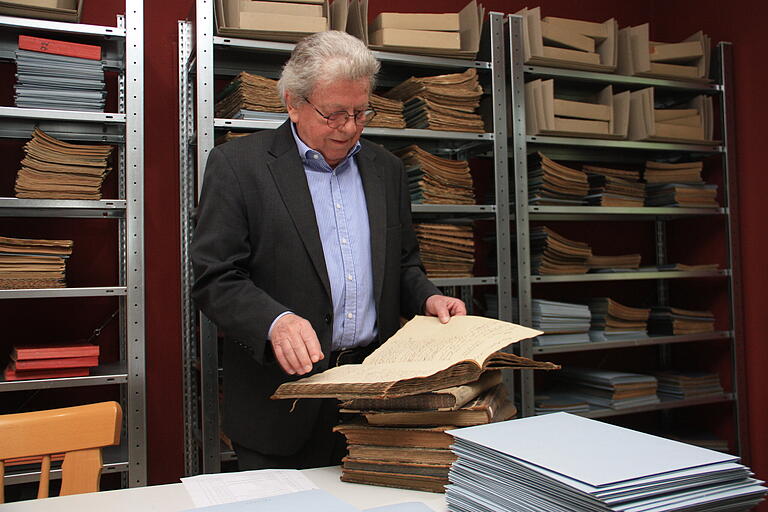 Archivar Marian Opalka blättert in einem alten Zensurbuch der Rügshöfer Dorfschule.