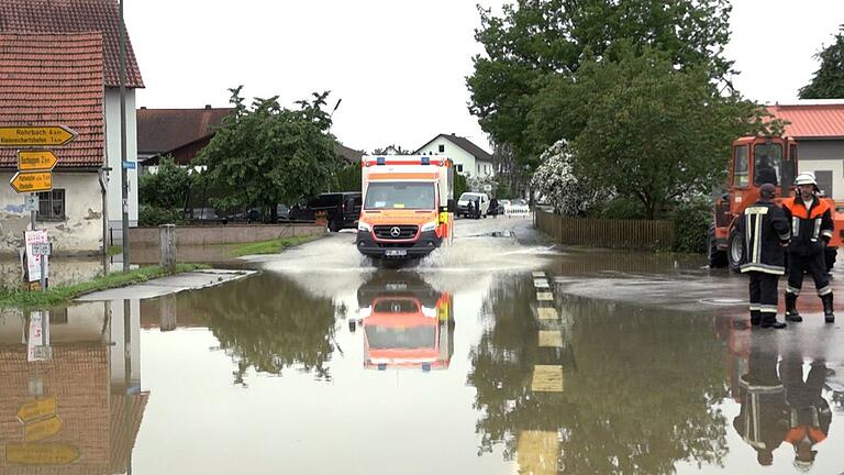 Hochwasser in Bayern - Pfaffenhofen an der Ilm       -  Ein Krankenwagen fährt über eine überschwemmte Straße in Pfaffenhofen an der Ilm.