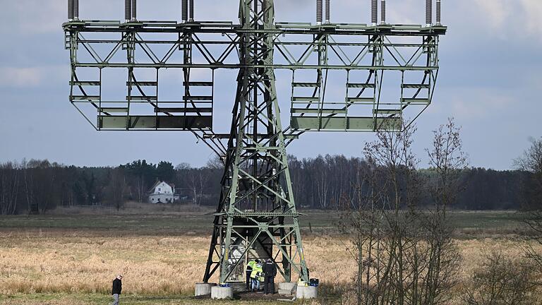 Stillstand nach Stromausfall.jpeg       -  Polizisten ermitteln an dem beschädigten Strommast auf einem Feld in Spreenhagen.