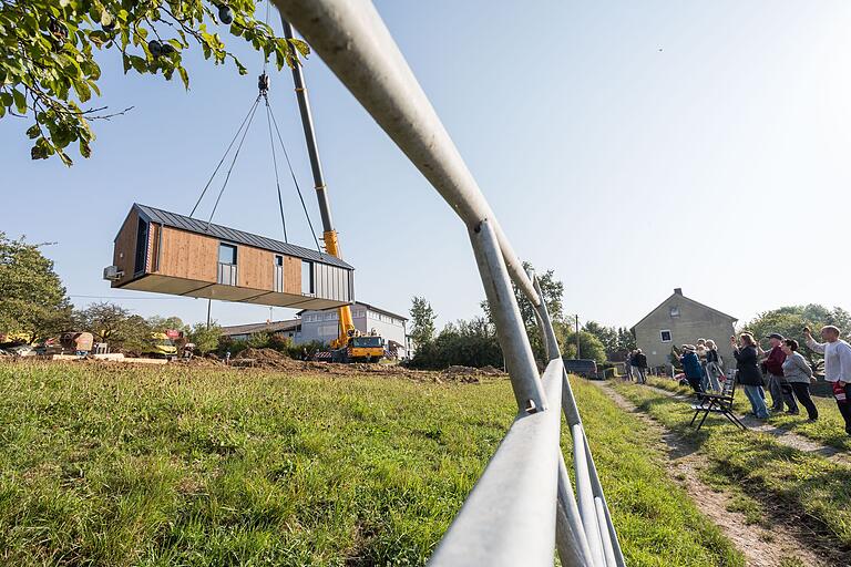 Langsam lässt der Kran das Tiny House herunter. Ob auch alles klappt? Das Spektakel zieht Schaulustige an.